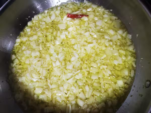 Sofrito de cebolla y ajo pochando en la sartén