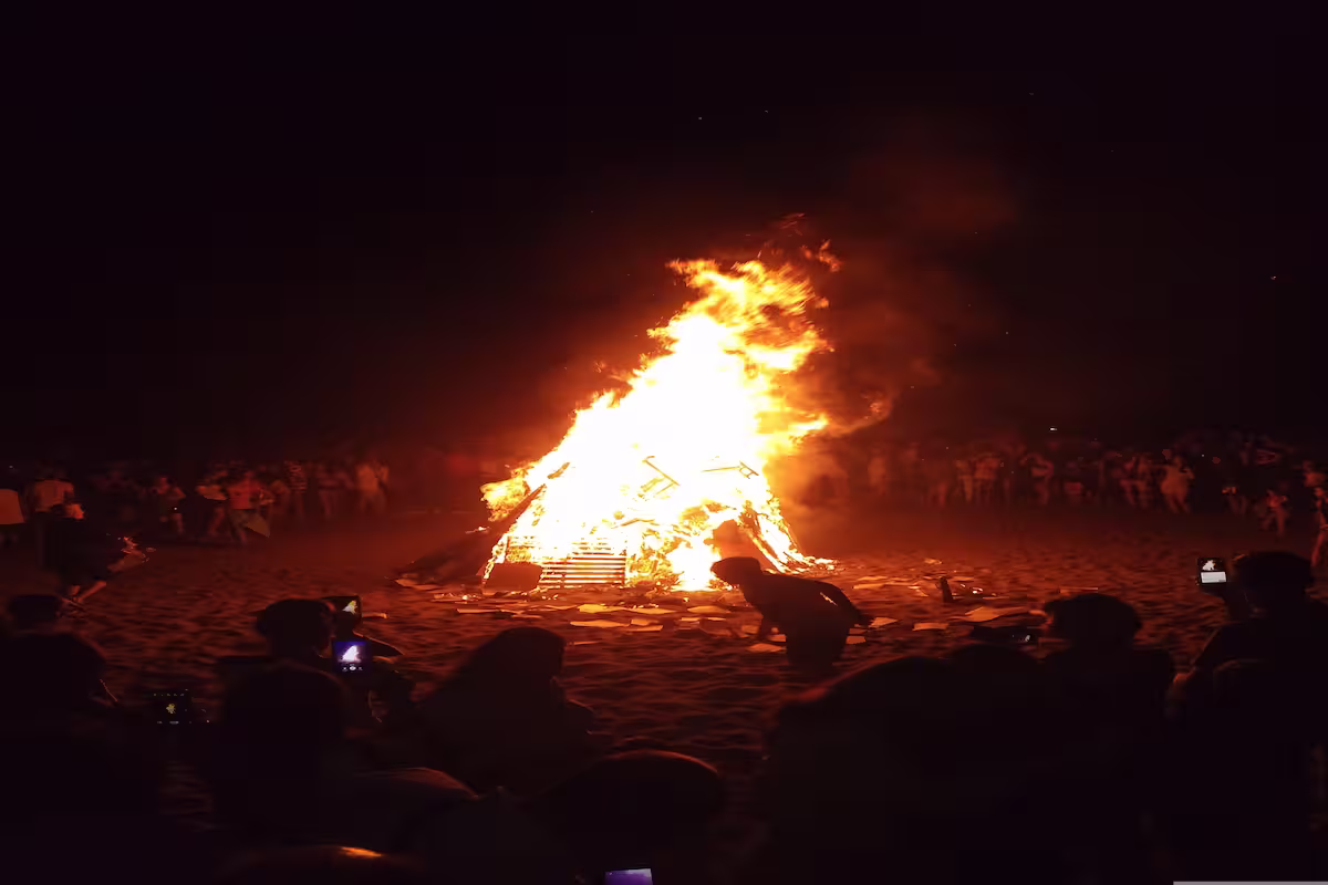 Noche de San Xoán en la playa de Riazor, A Coruña, con miles de personas alrededor de las hogueras