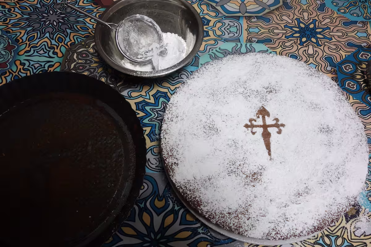 粉砂糖を使ってサンティアゴの十字架でケーキを飾る