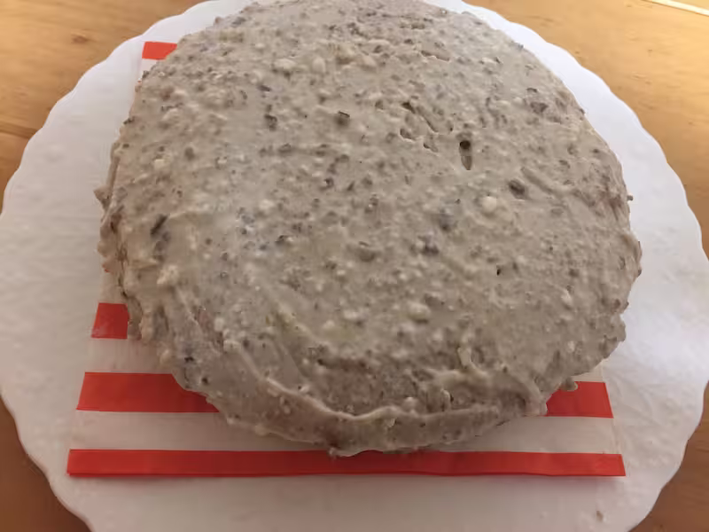 Tarta montada y cubierta completamente con la crema blanca